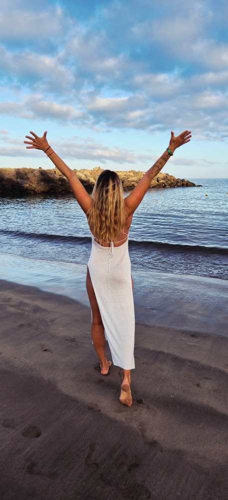 Majitelka na plazi v joga poze